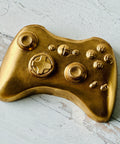 a close up of a gold controller on a wooden surface