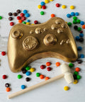 a gold game controller surrounded by candy and candies