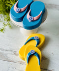 a pair of blue and yellow flip flops sitting on top of a table