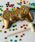 a gold video game controller next to some candy