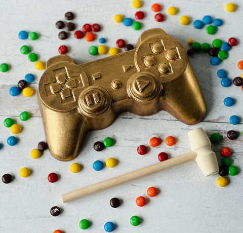 a gold video game controller next to some candy