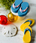 a pair of flip flops sitting next to a sand dollar