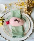 a place setting with a pink egg and napkin