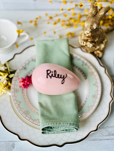 a place setting with a pink egg and napkin