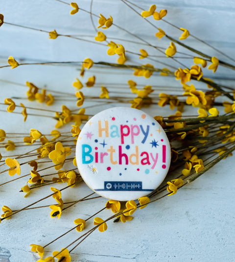 a button that says happy birthday surrounded by yellow flowers