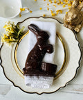 a chocolate bunny sitting on top of a white plate